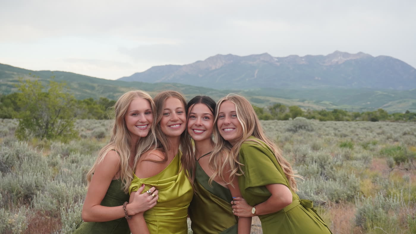 Bridesmaids in green dresses in front of the mountains